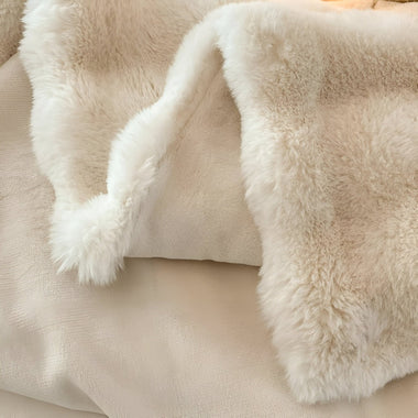 Close-up of a fluffy beige blanket with soft texture